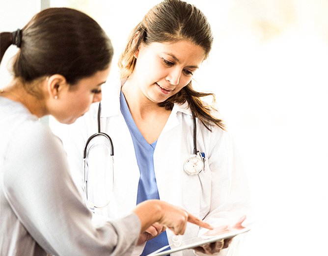 Image of a female medical staff member reviewing documents with a female patient.