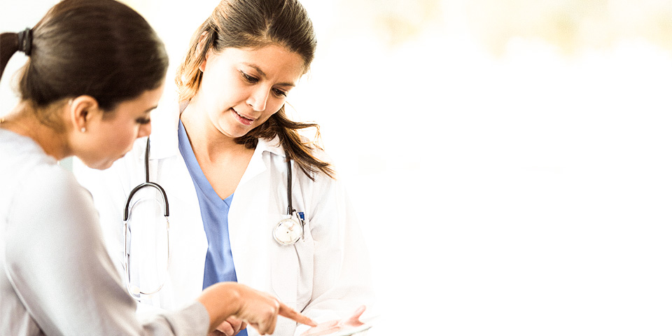 Image of a female medical staff member reviewing documents with a female patient.