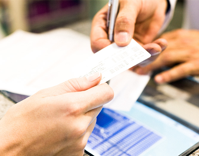 Image of two set of hands exchanging documents.