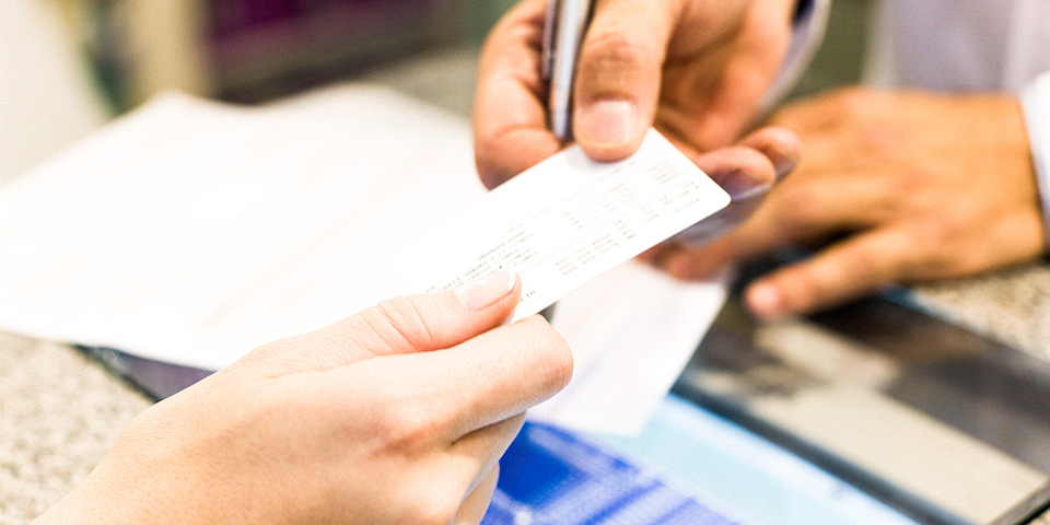 Image of two set of hands exchanging documents.