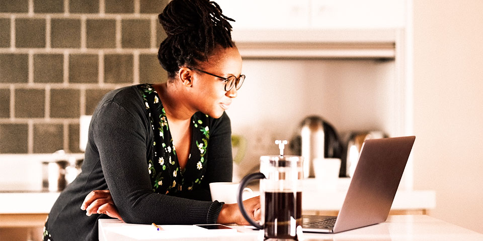 Woman sitting at a desk viewing content on a laptop computer