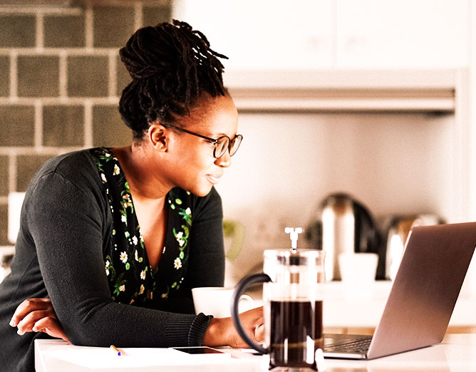 Woman sitting at a desk viewing content on a laptop computer